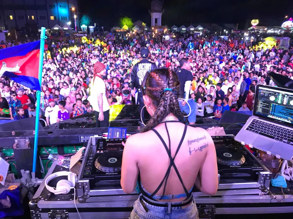 DJ VOCKA behind the decks in daylight facing a provincial festival crowd