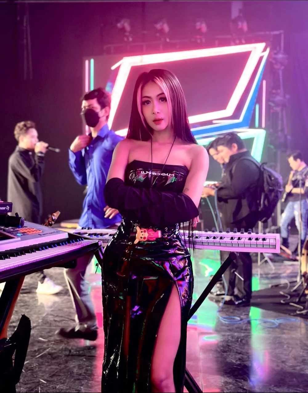 DJ VOCKA in black latex on a neon-lit stage