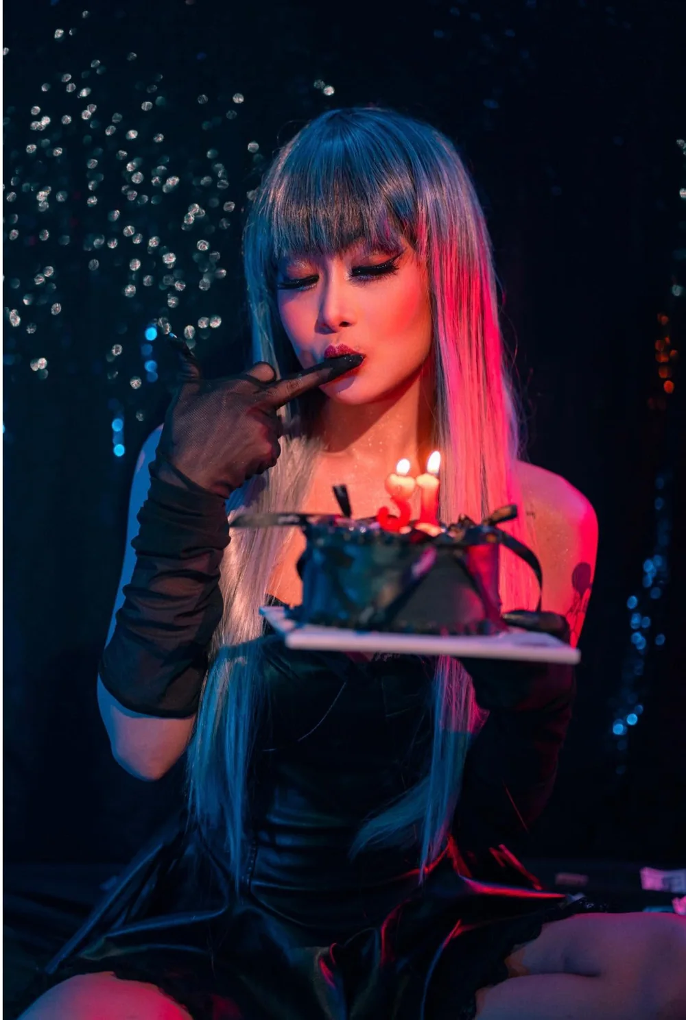 DJ VOCKA with teal hair under red and blue light